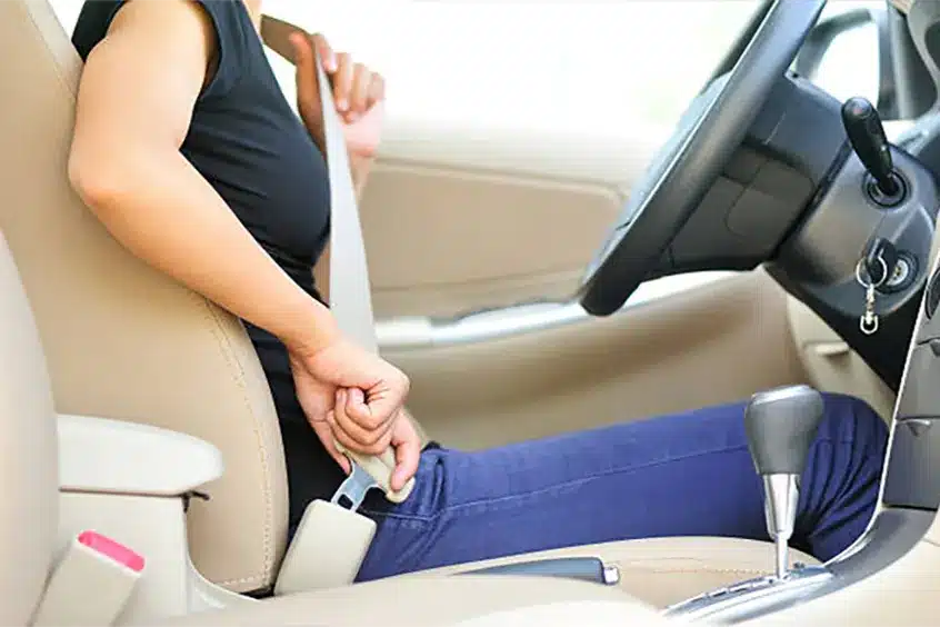 Driver fastening a seat belt